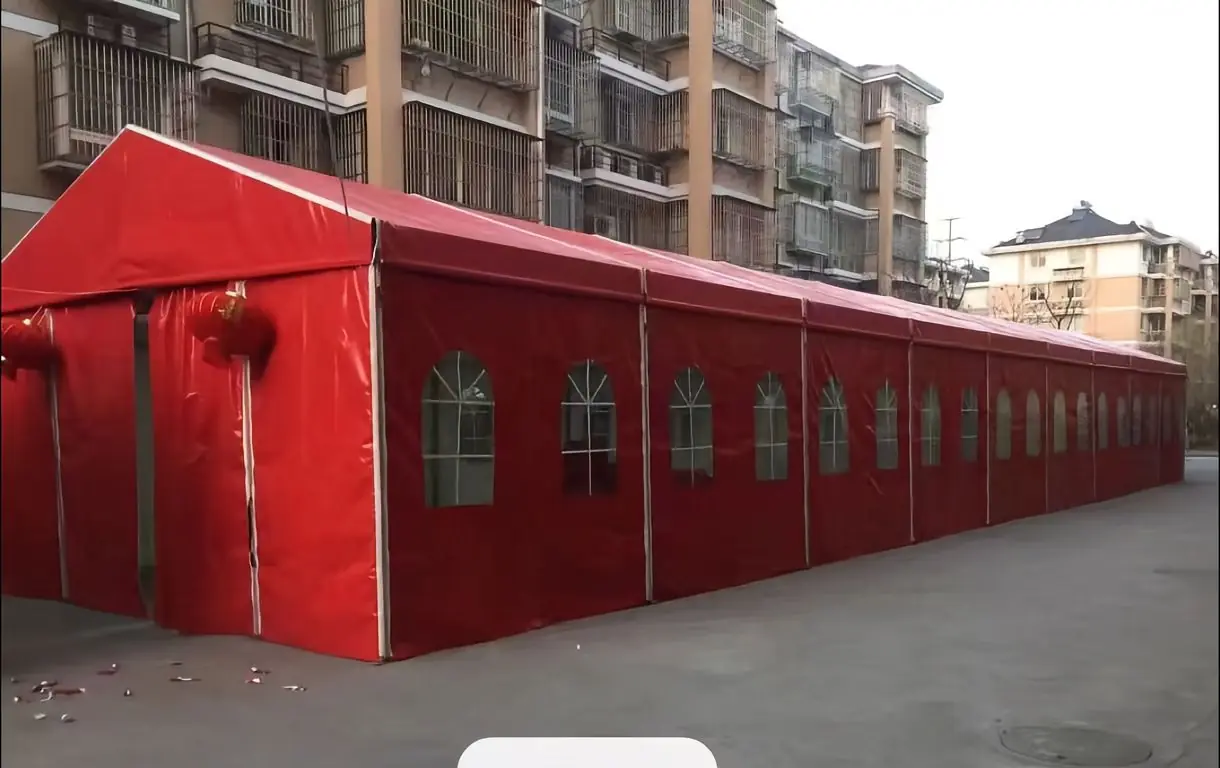 Side angle of the red exterior wedding marquee by Superb Holaj Tent during a sunny outdoor event