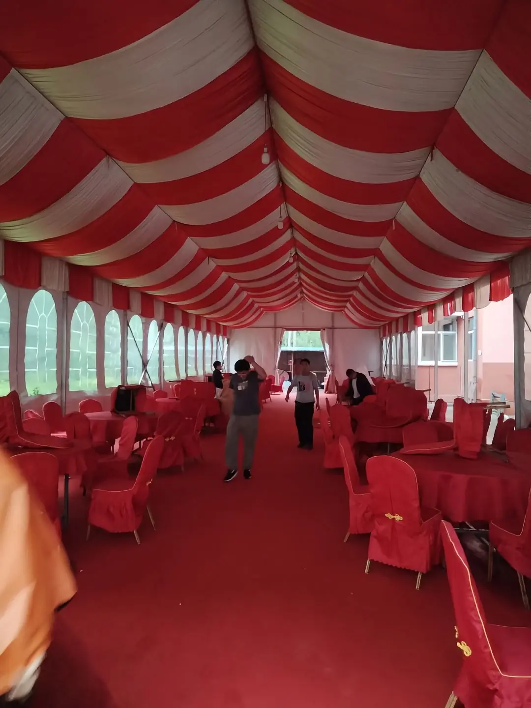 Interior view of 10x45m red and white wedding tent with banquet-style seating arrangement